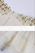 Pearl-trimmed fabric with a zipper and sheer fabric on a white background