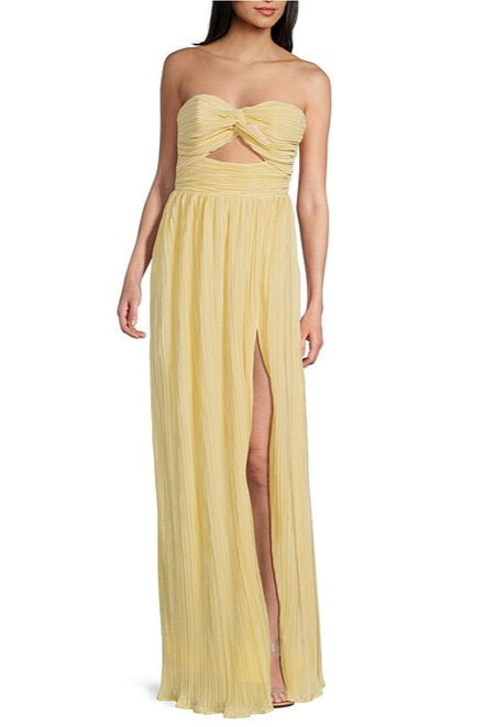 A strapless pleated maxi dress in a lemon yellow color with a flowy design and a cutout at the bodice. The dress features a pleated skirt, a side slit, and an elastic back with a zipper.