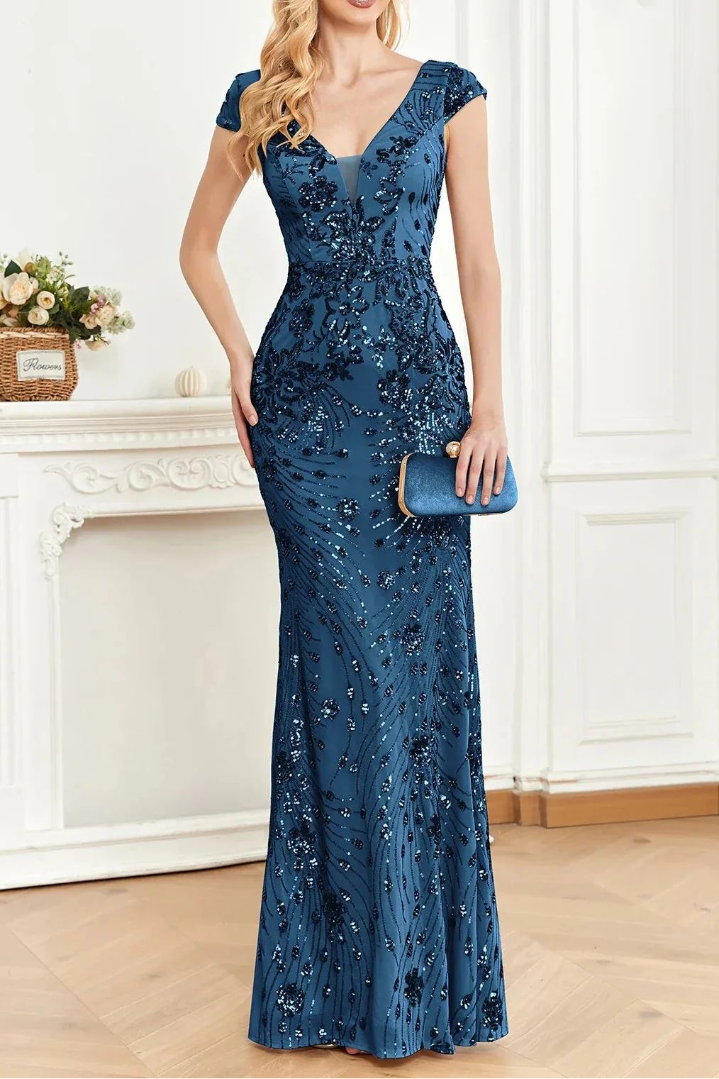 Woman wearing a blue sequin dress in an elegant room.
